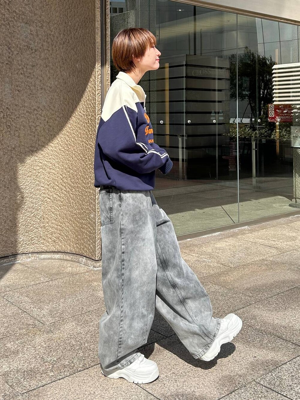 ブルー系のスウェット、ブラック系のデニムパンツを着用したレディースの春コーディネートの3枚目の写真