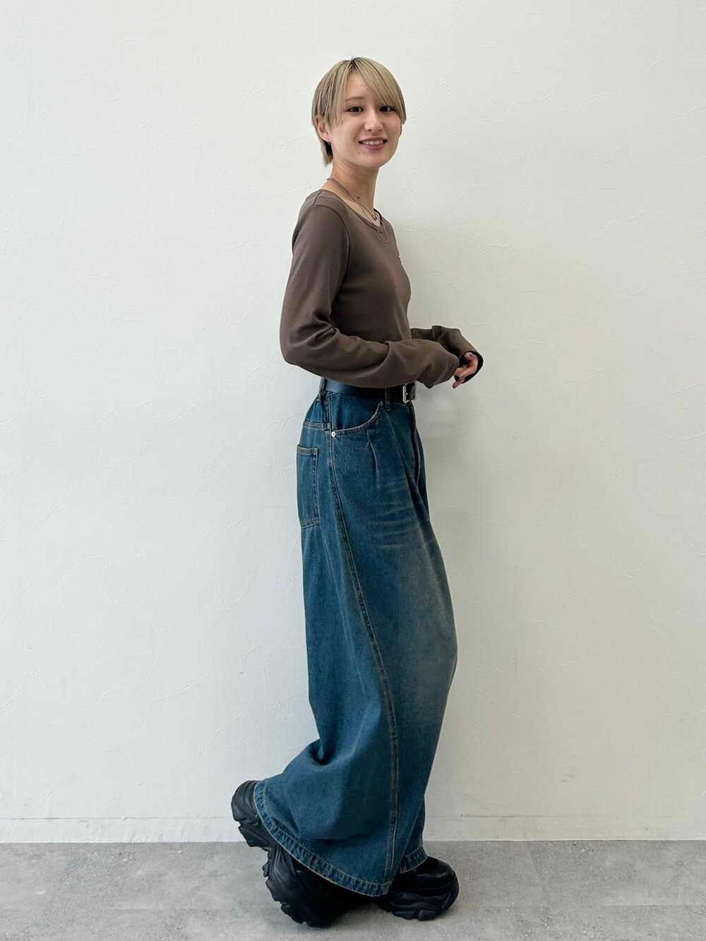 ブラック系のスニーカー、ブルー系のデニムパンツ、ブラウン系のTシャツ/カットソーを着用したレディースの春コーディネートの3枚目の写真