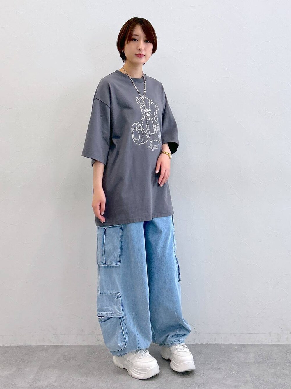 グレー系のTシャツ/カットソー、ブルー系のデニムパンツ、シルバー系のネックレスを着用したレディースの夏コーディネートの3枚目の写真