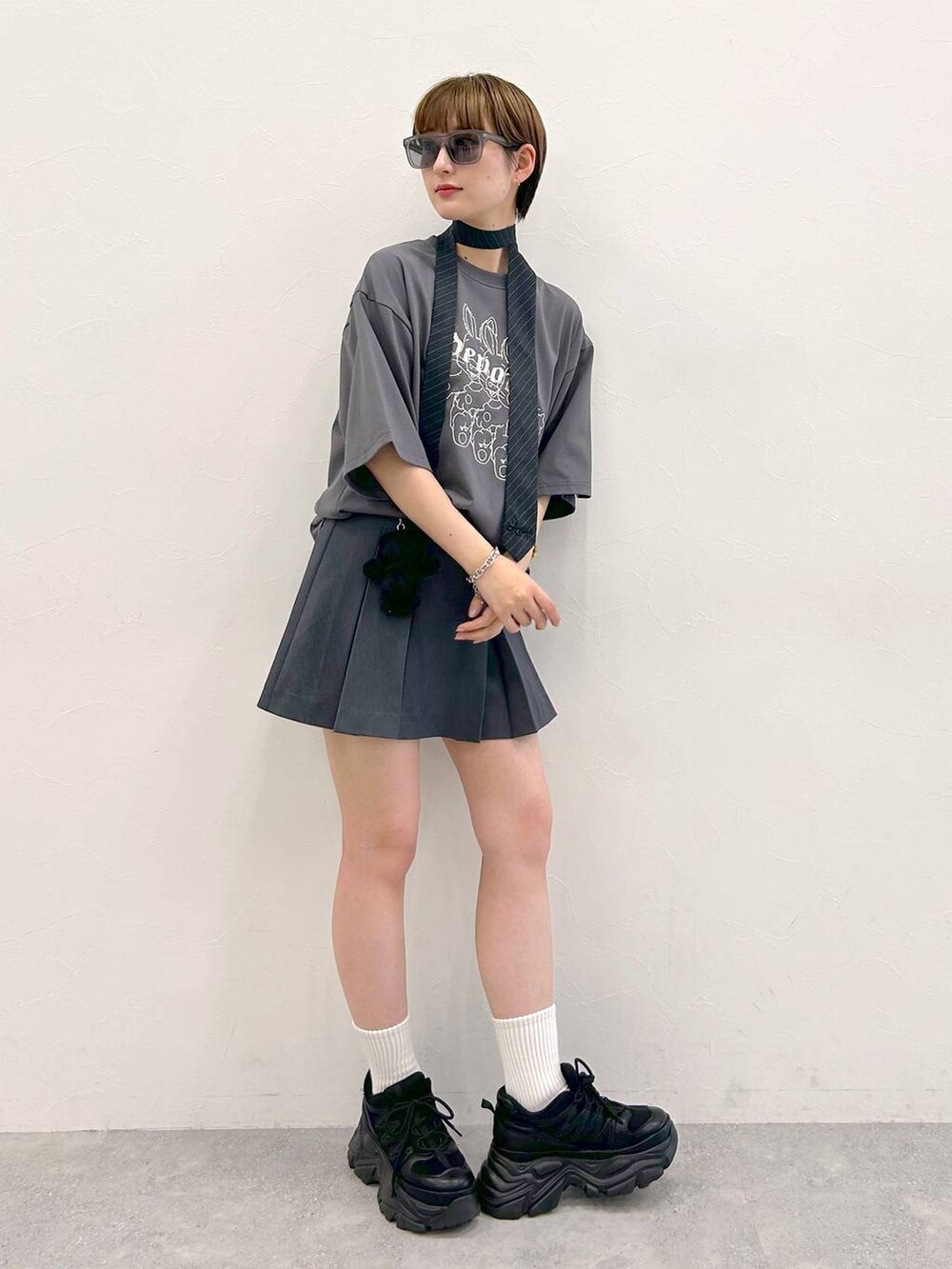 ブラック系のスニーカー、グレー系のTシャツ/カットソー、グレー系のネクタイを着用したレディースの夏コーディネートの5枚目の写真