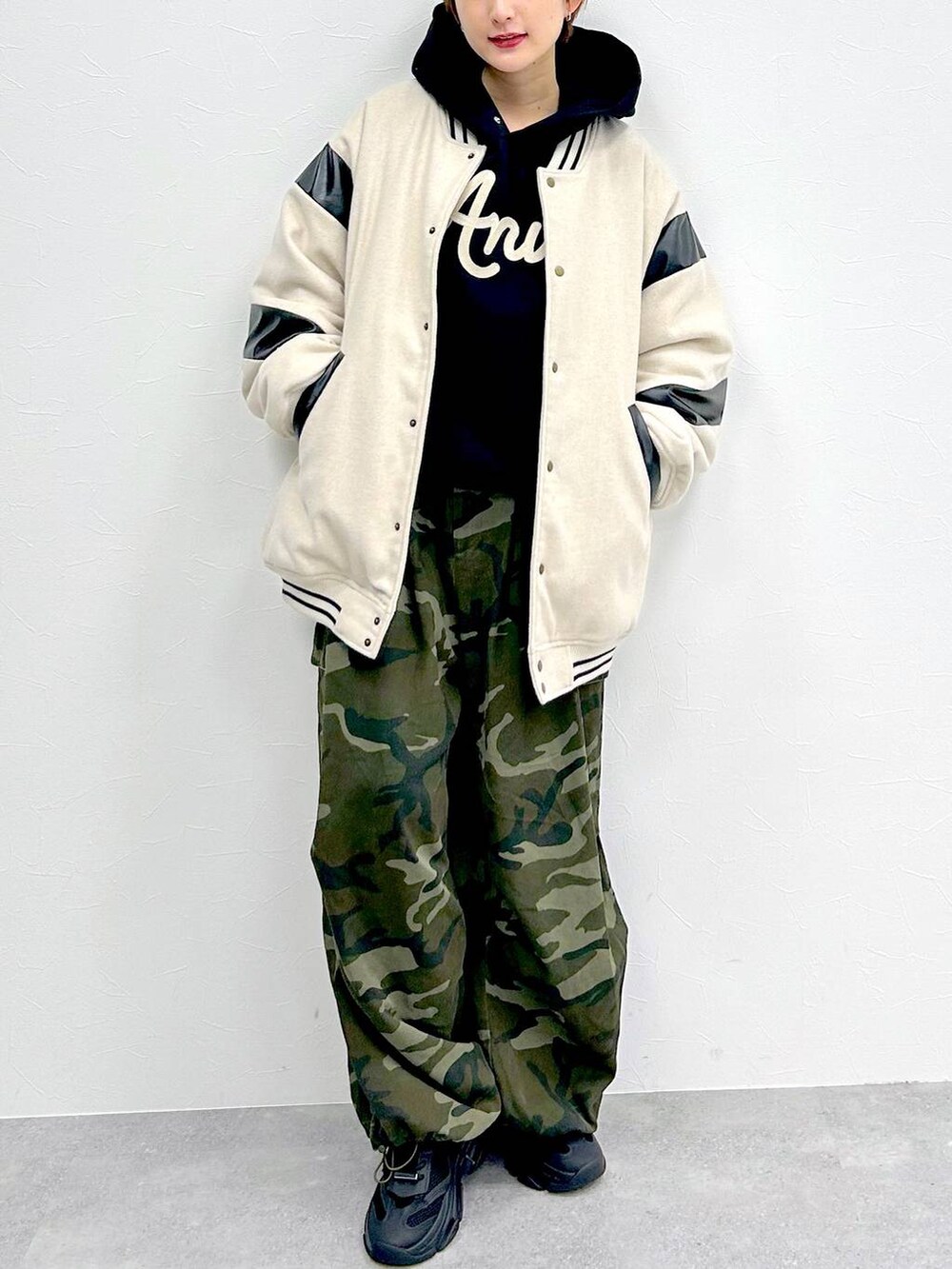 ブラック系のパーカー、グリーン系のその他パンツ、ベージュ系のスタジャンを着用したレディースの冬コーディネートの2枚目の写真