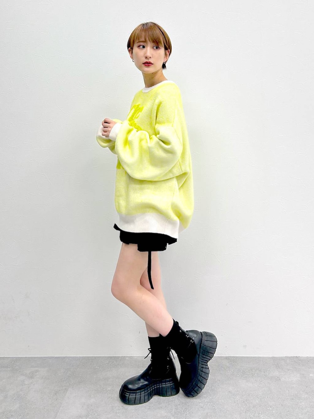 ホワイト系のニット/セーター、ブラック系のブーツ、ブラック系のスカートを着用したレディースの冬コーディネートの3枚目の写真