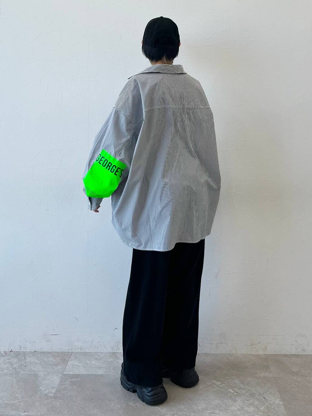 ブラック系のスニーカー、ブラック系のチノパンツ、ブラック系のキャップを着用したレディースの春コーディネートの7枚目の写真