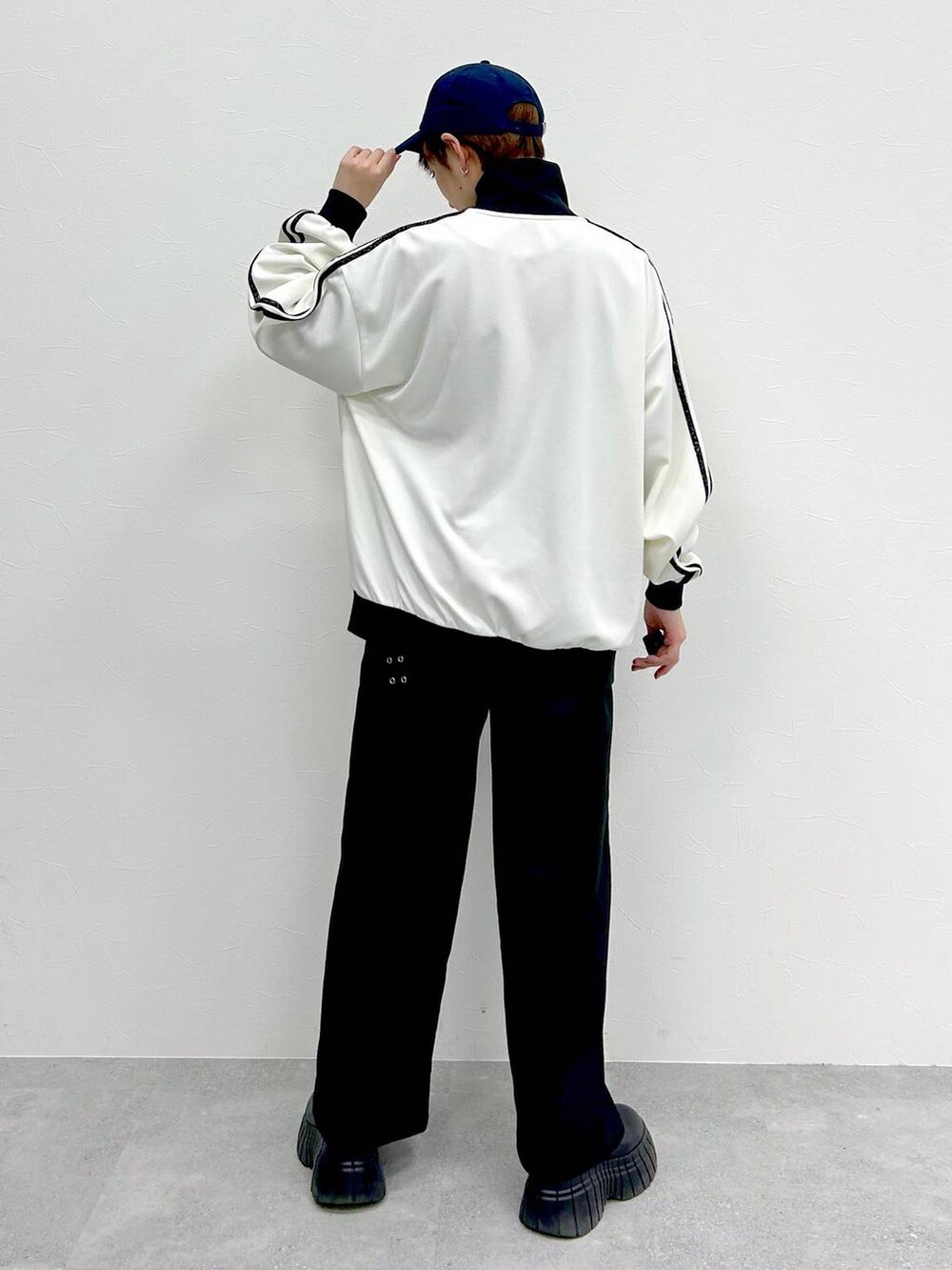 ホワイト系のその他アウター、ブラック系のスラックス、ブラック系のブーツを着用したレディースの春コーディネートの7枚目の写真