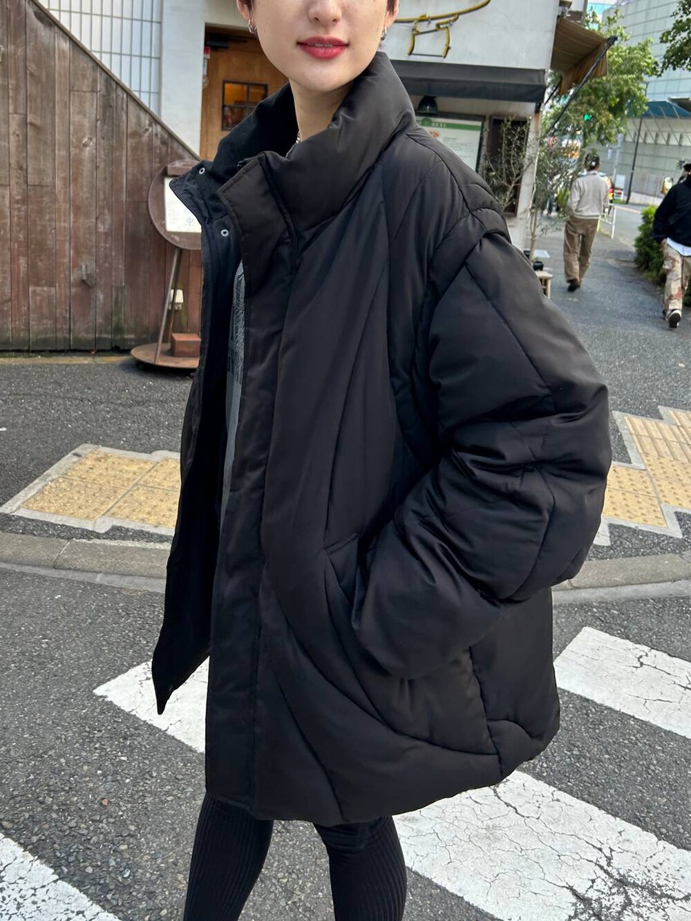 ブラック系のブルゾン、ブラック系のブーツ、ブラック系のスカートを着用したレディースの冬コーディネートの7枚目の写真