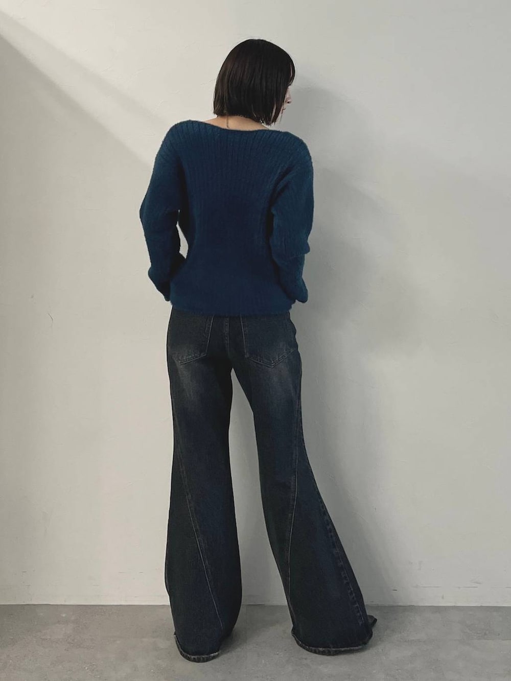 ブルー系のデニムパンツ、ブラック系のパンプス、グリーン系のニット/セーターを着用したレディースの秋コーディネートの7枚目の写真