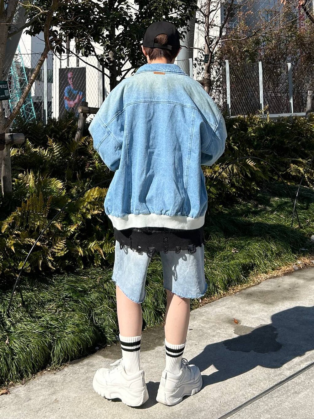 ブルー系のデニムジャケット、ブルー系のデニムパンツ、ブラック系のカーディガン/ボレロを着用したレディースの春コーディネートの6枚目の写真