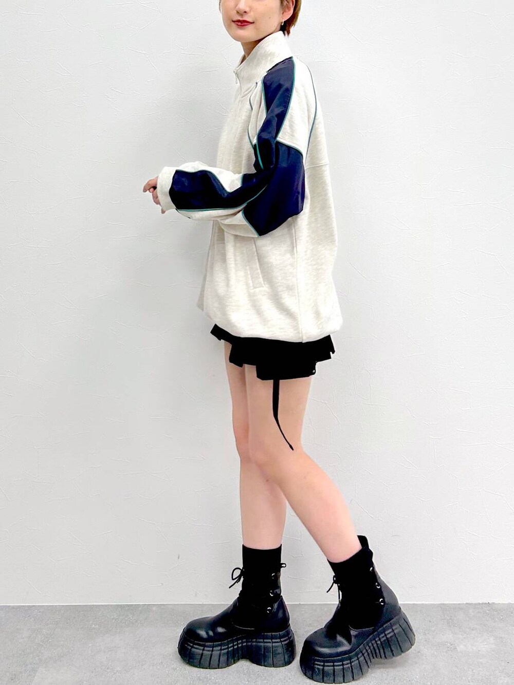 ブラック系のブーツ、ブラック系のスカート、ベージュ系のスウェットを着用したレディースの冬コーディネートの4枚目の写真