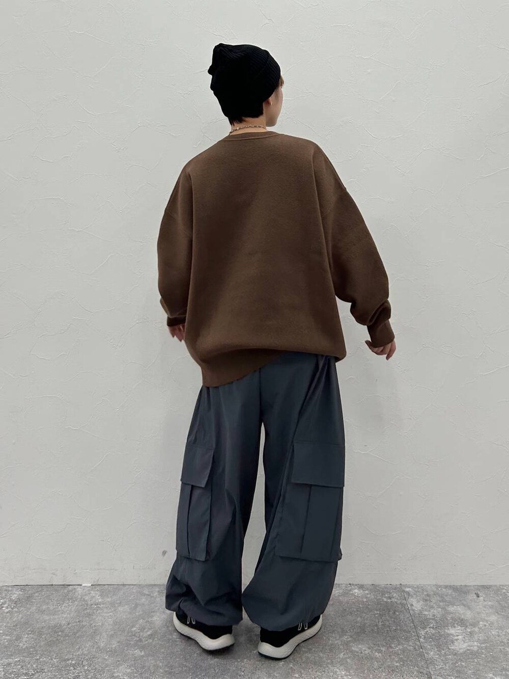 グレー系のカーゴパンツ、ブラウン系のニット/セーター、ブラック系のニットキャップ/ビーニーを着用したレディースの秋コーディネートの7枚目の写真