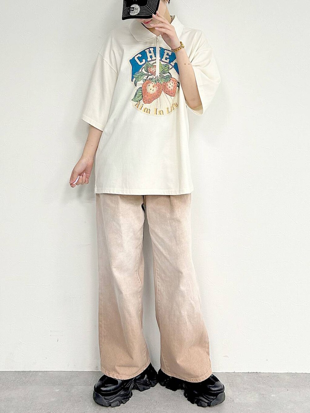 ピンク系のデニムパンツ、ブラック系のスニーカー、ホワイト系のTシャツ/カットソーを着用したレディースの夏コーディネートの3枚目の写真