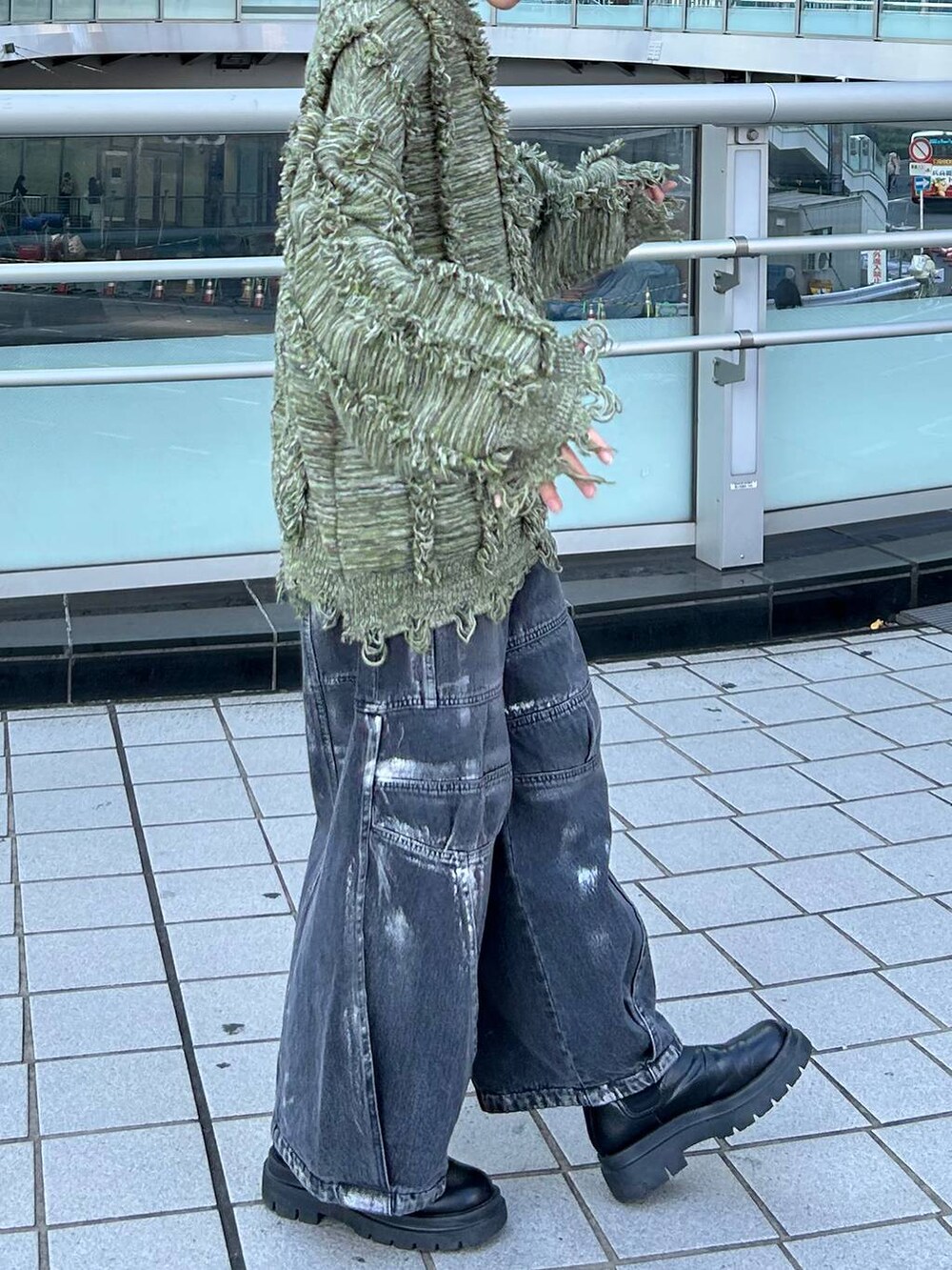 グリーン系のニット/セーター、ブラック系のデニムパンツを着用したレディースの冬コーディネートの5枚目の写真