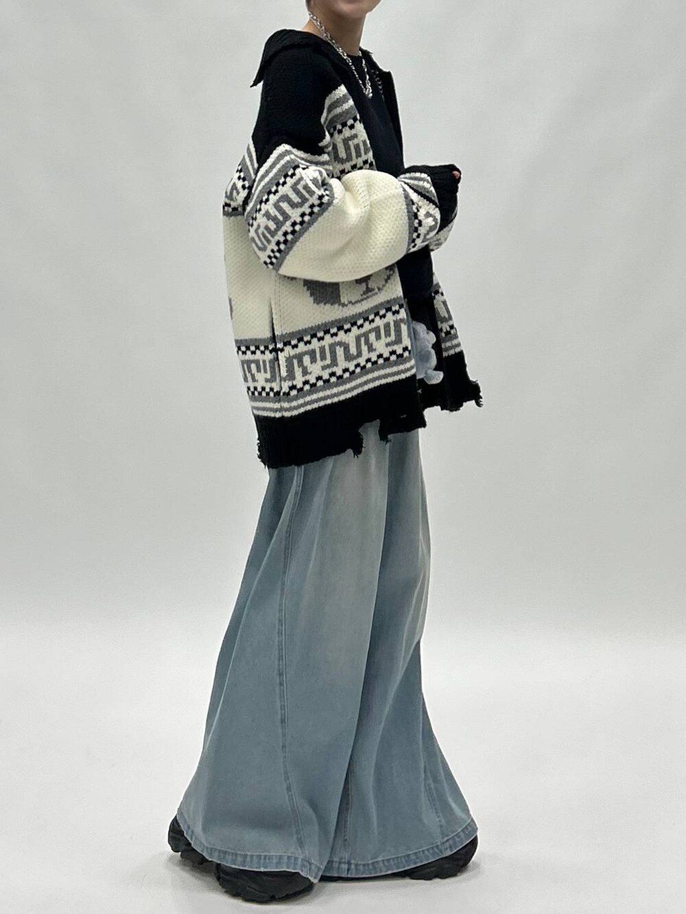 ブルー系のデニムパンツ、ブラック系のブーツ、ブラック系のスウェットを着用したレディースの秋コーディネートの7枚目の写真