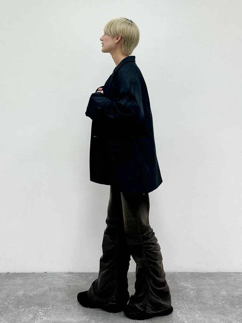 ブラック系のデニムパンツ、ブラック系のテーラードジャケット、グリーン系のニット/セーターを着用したレディースの秋コーディネートの5枚目の写真