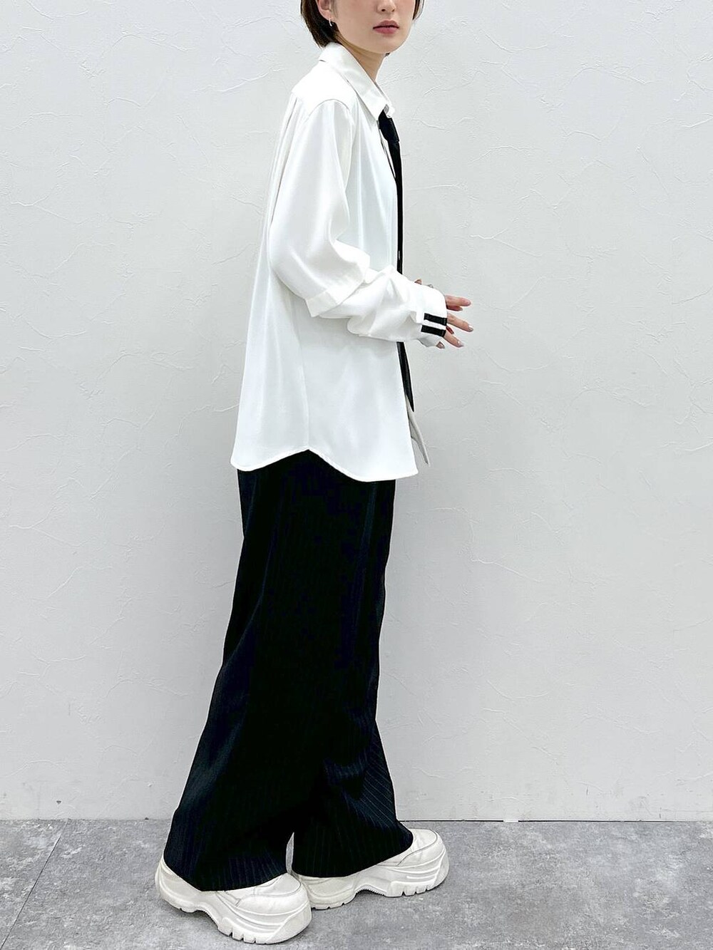 ブラック系のネクタイ、ホワイト系のシャツ/ブラウス、ブラック系のスラックスを着用したレディースの春コーディネートの5枚目の写真