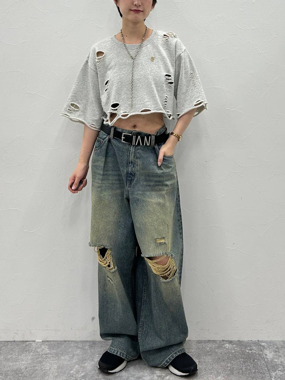 グレー系のTシャツ/カットソー、ブルー系のデニムパンツ、グリーン系のキャップを着用したレディースの秋コーディネートの2枚目の写真