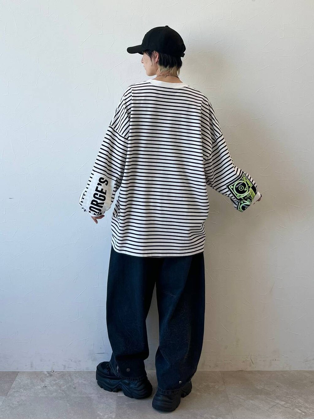 ブラック系のスニーカー、ブラック系のデニムパンツ、ブラック系のキャップを着用したレディースの春コーディネートの8枚目の写真