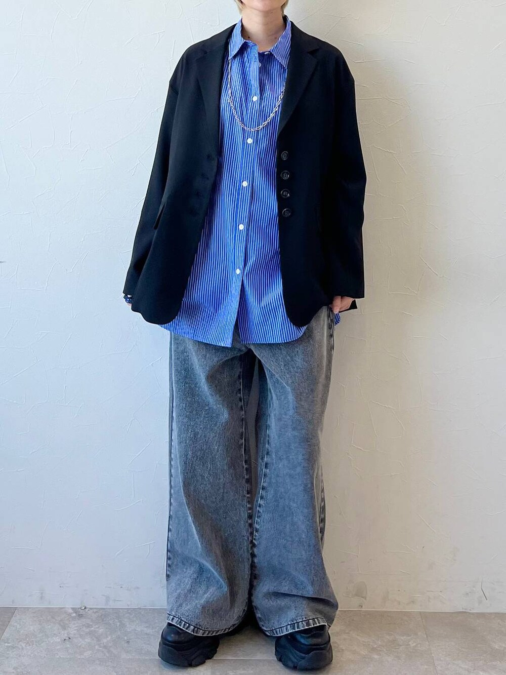 ブラック系のスニーカー、ブラック系のテーラードジャケット、ブラック系のデニムパンツを着用したレディースの春コーディネートの2枚目の写真