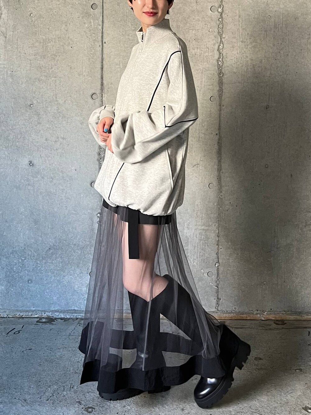 ブラック系のブーツ、グレー系のスウェット、グレー系のスカートを着用したレディースの冬コーディネートの5枚目の写真