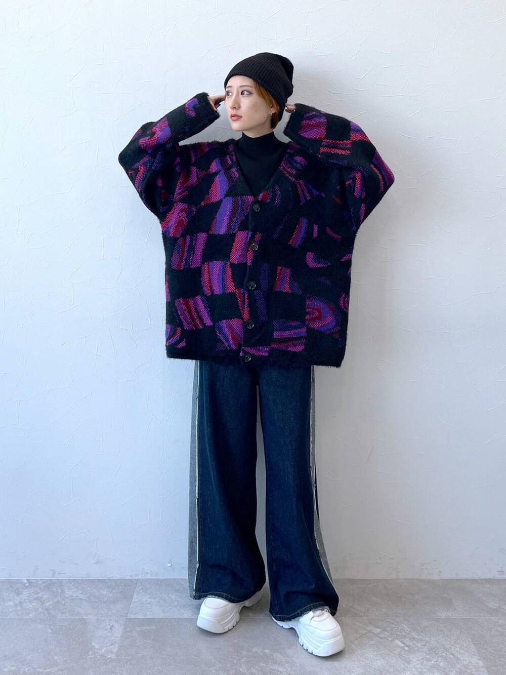 ブルー系のデニムパンツ、ブラック系のニット/セーター、ブラック系のニットキャップ/ビーニーを着用したレディースの秋コーディネートの3枚目の写真