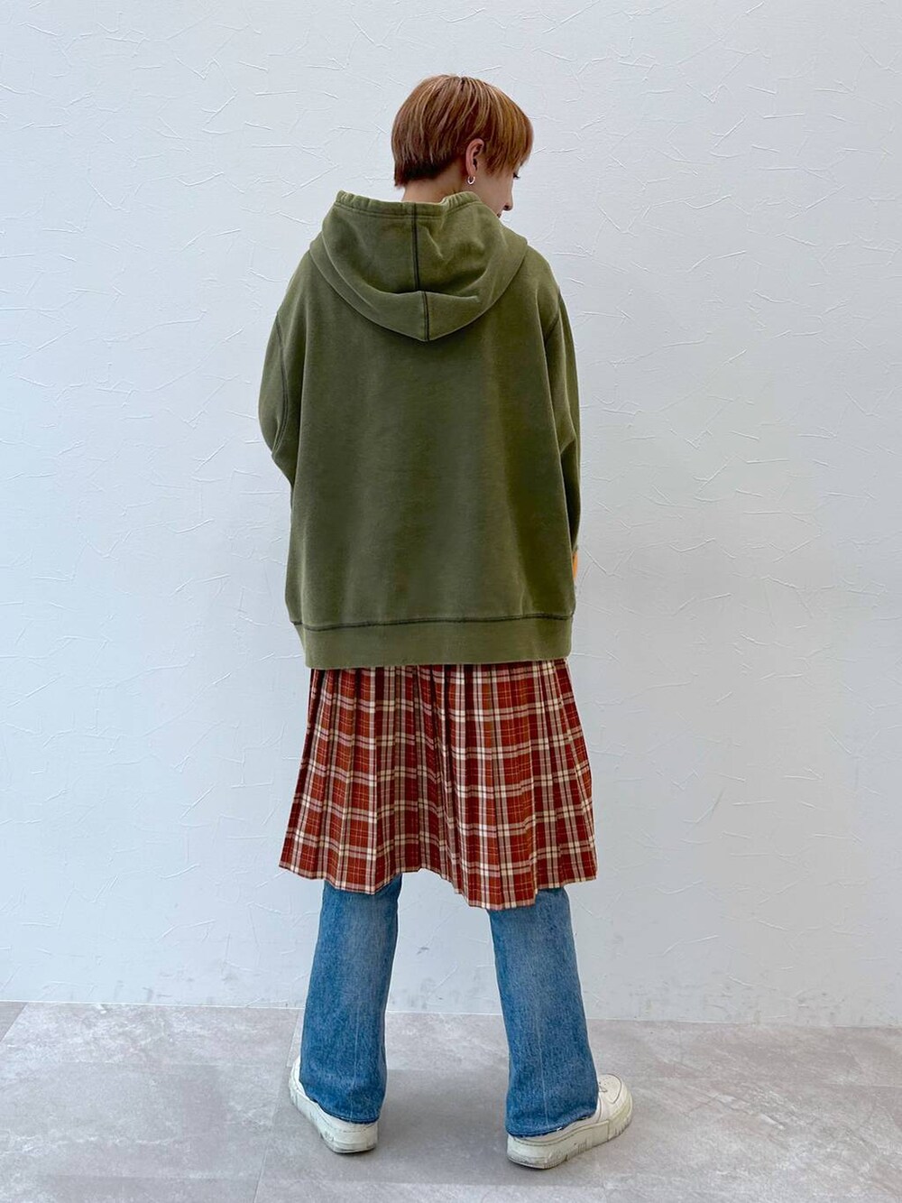 グリーン系のパーカー、レッド系のスカートを着用したレディースの秋コーディネートの5枚目の写真