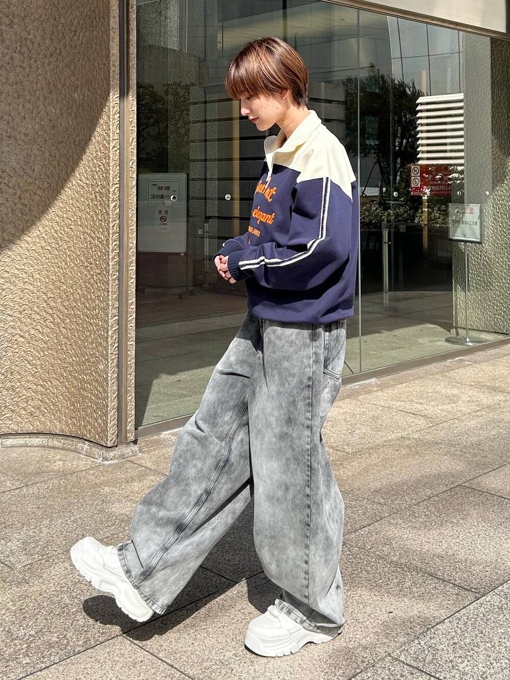 ブルー系のスウェット、ブラック系のデニムパンツを着用したレディースの春コーディネートの5枚目の写真