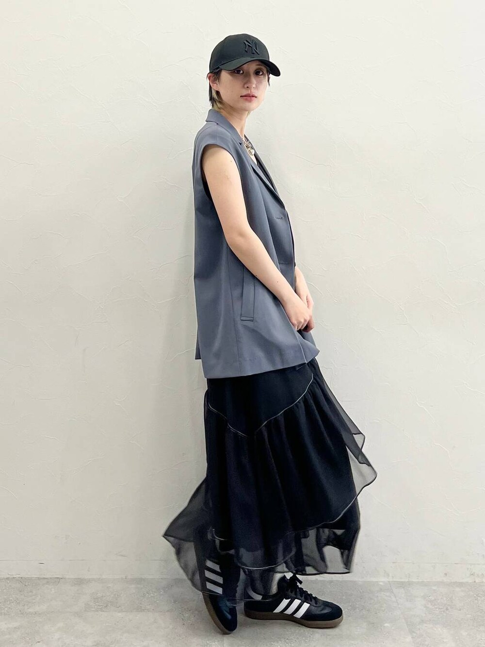 ブラック系のスカート、ブラック系のスニーカー、ブラック系のキャミソールを着用したレディースの春コーディネートの4枚目の写真