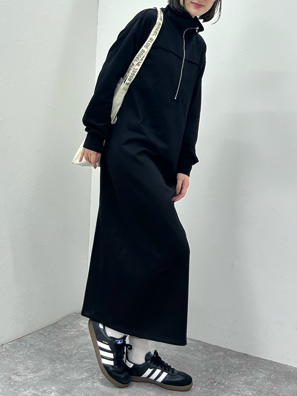ブラック系のワンピース、ブラック系のスニーカーを着用したレディースの秋コーディネートの3枚目の写真
