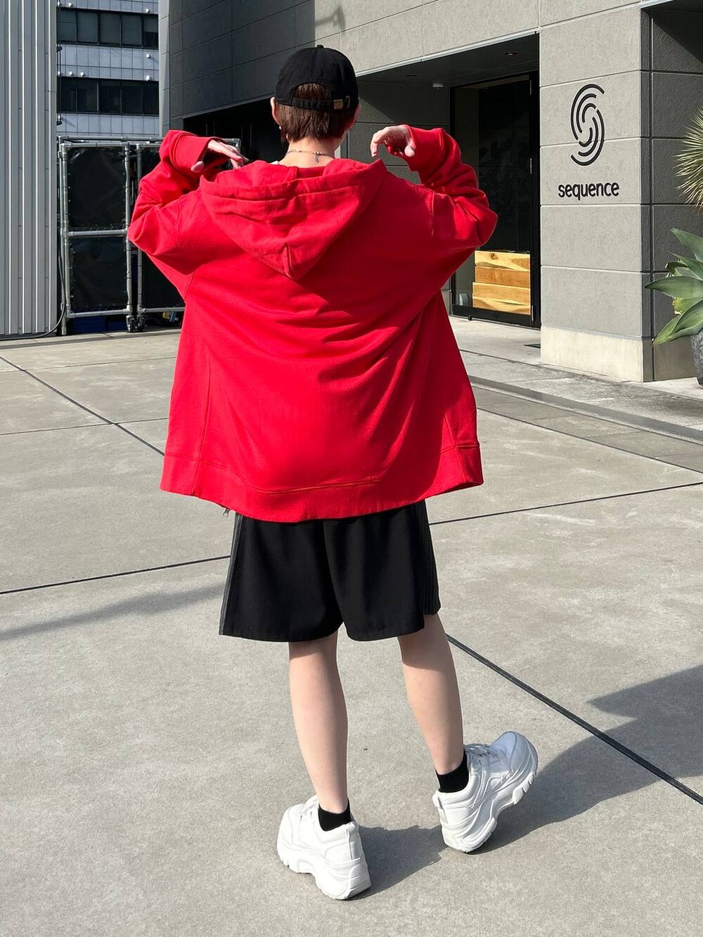 レッド系のパーカー、ホワイト系のニット/セーター、ブラック系のスラックスを着用したレディースの冬コーディネートの8枚目の写真