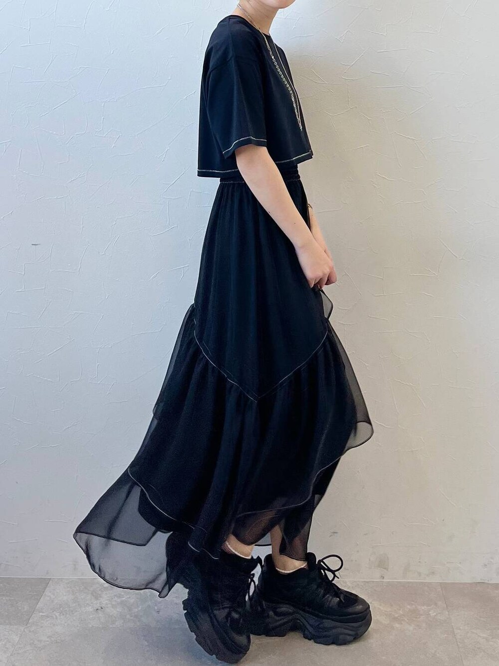 ブラック系のスニーカー、ブラック系のスカート、ブラック系のTシャツ/カットソーを着用したレディースの春コーディネートの4枚目の写真