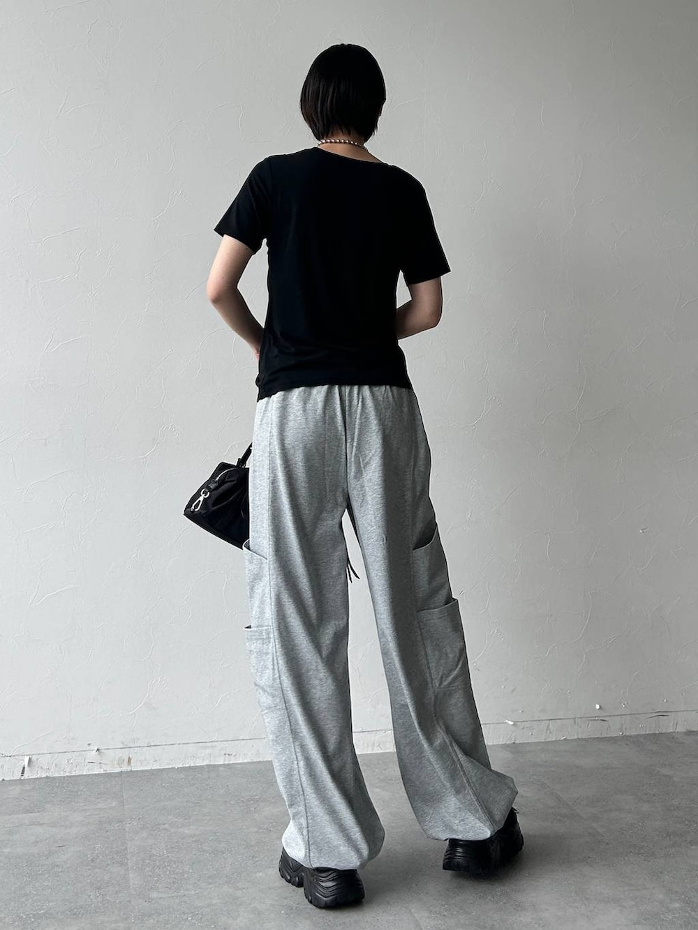 ブラック系のサンダル、ブラック系のトートバッグ、ブラック系のTシャツ/カットソーを着用したレディースの春コーディネートの6枚目の写真