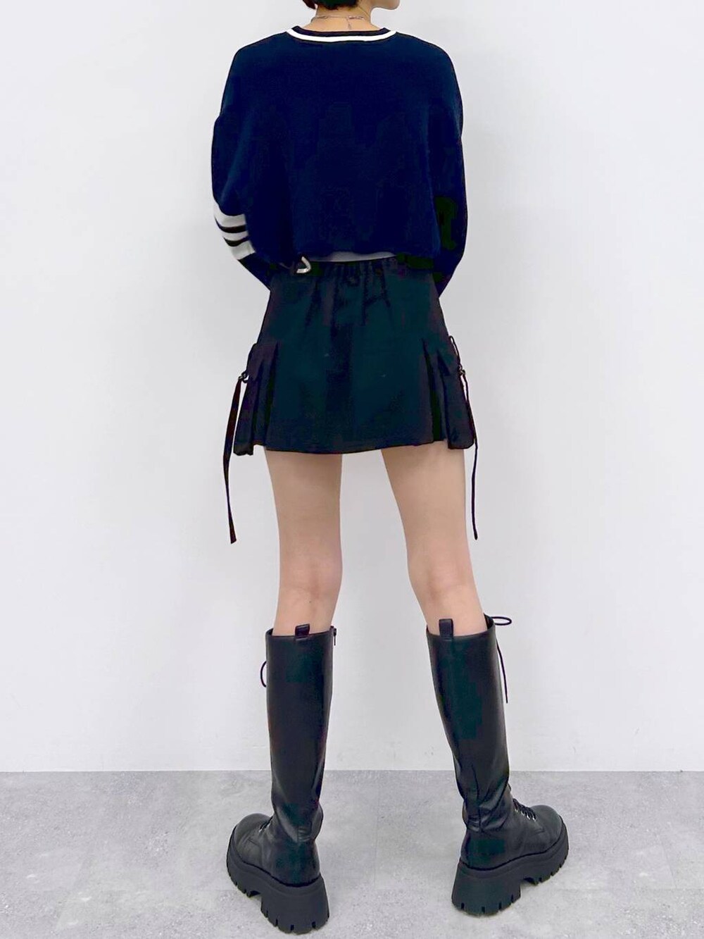 ブラック系のブーツ、ブラック系のスカート、ブルー系のニット/セーターを着用したレディースの冬コーディネートの7枚目の写真