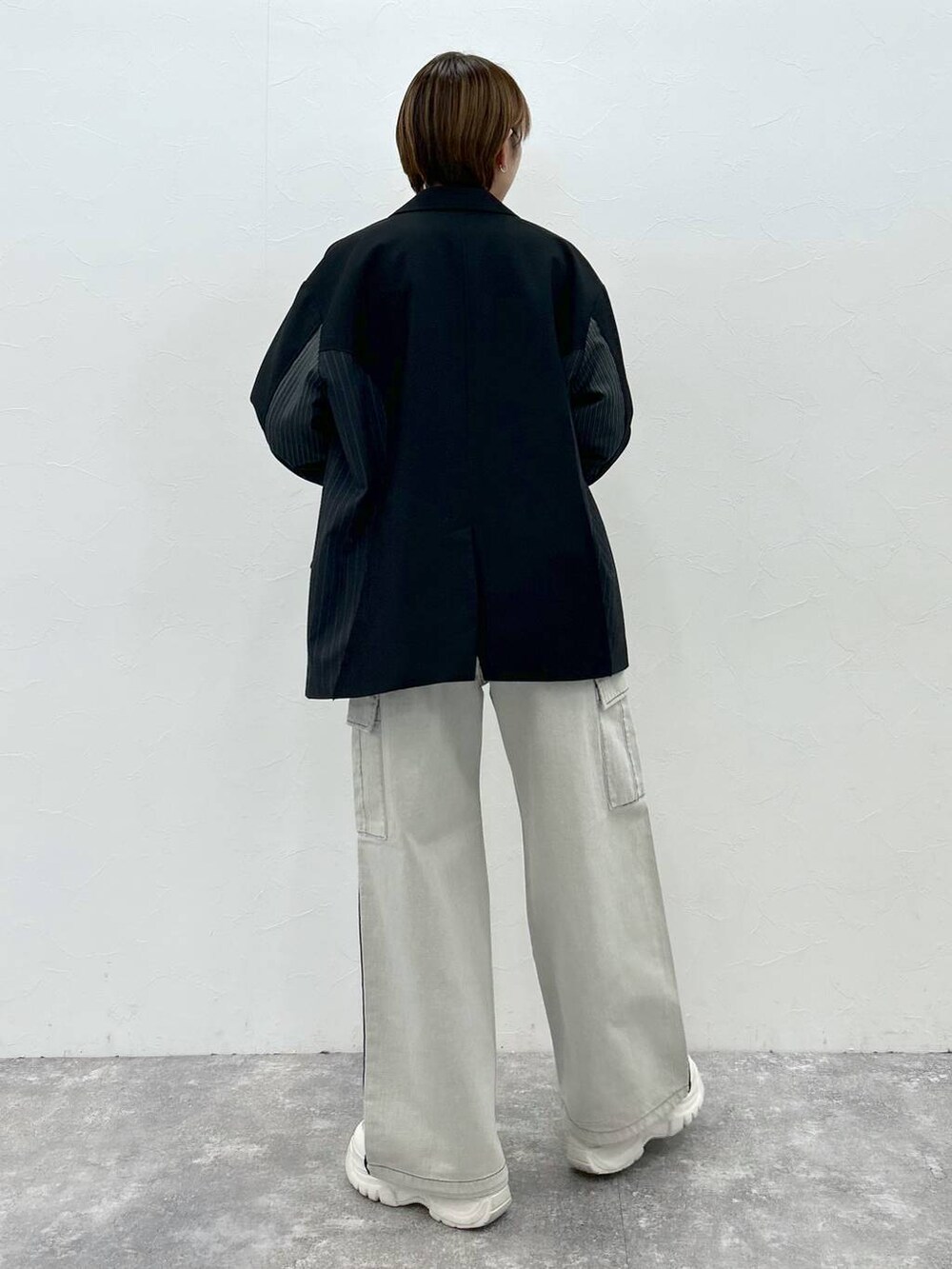 ブラック系のテーラードジャケット、ホワイト系のデニムパンツ、ブラック系のTシャツ/カットソーを着用したレディースの春コーディネートの6枚目の写真