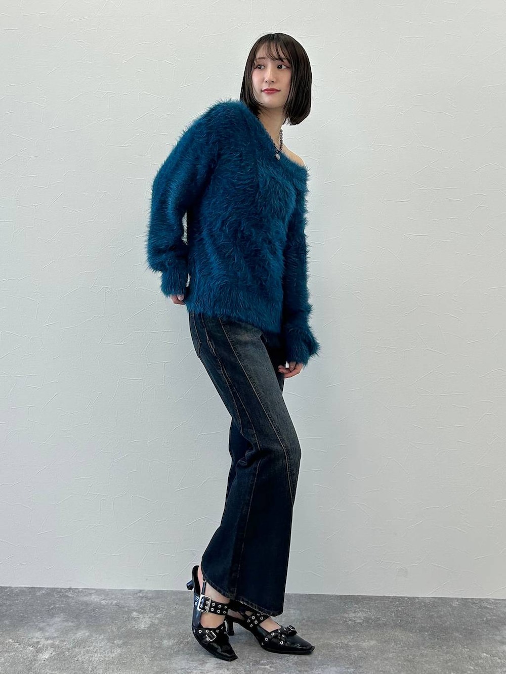 ブルー系のデニムパンツ、ブラック系のパンプス、ブルー系のニット/セーターを着用したレディースの秋コーディネートの4枚目の写真