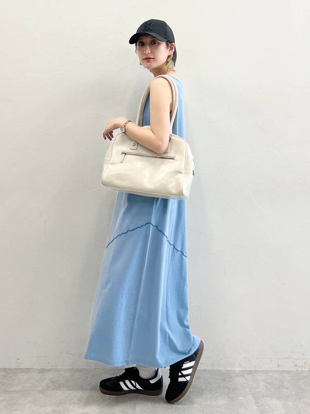 ホワイト系のボストンバッグ、ブラック系のスニーカー、ブルー系のワンピースを着用したレディースの春コーディネートの3枚目の写真