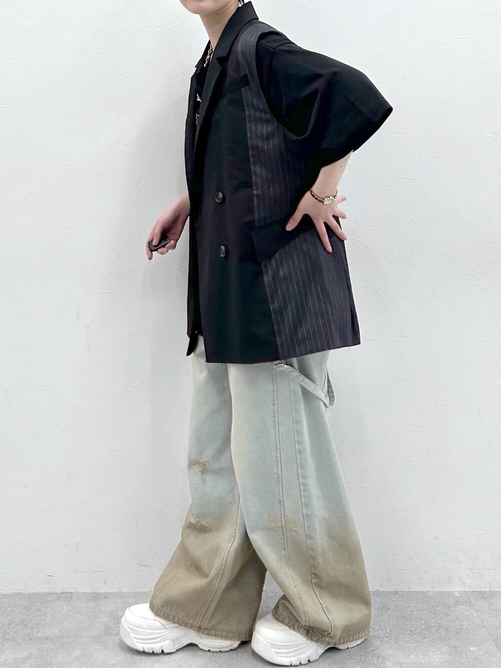 ブラック系のTシャツ/カットソー、ブルー系のデニムパンツ、ブラック系のテーラードジャケットを着用したレディースの春コーディネートの6枚目の写真