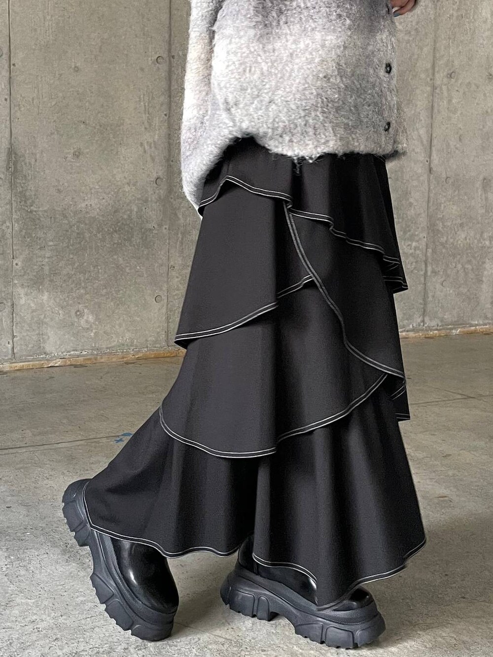 ホワイト系のキャミソール、ブラック系のブーツ、ホワイト系のクラッチバッグを着用したレディースの冬コーディネートの5枚目の写真