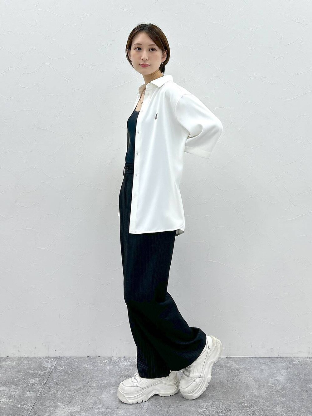 ホワイト系のシャツ/ブラウス、ブラック系のスラックスを着用したレディースの春コーディネートの3枚目の写真