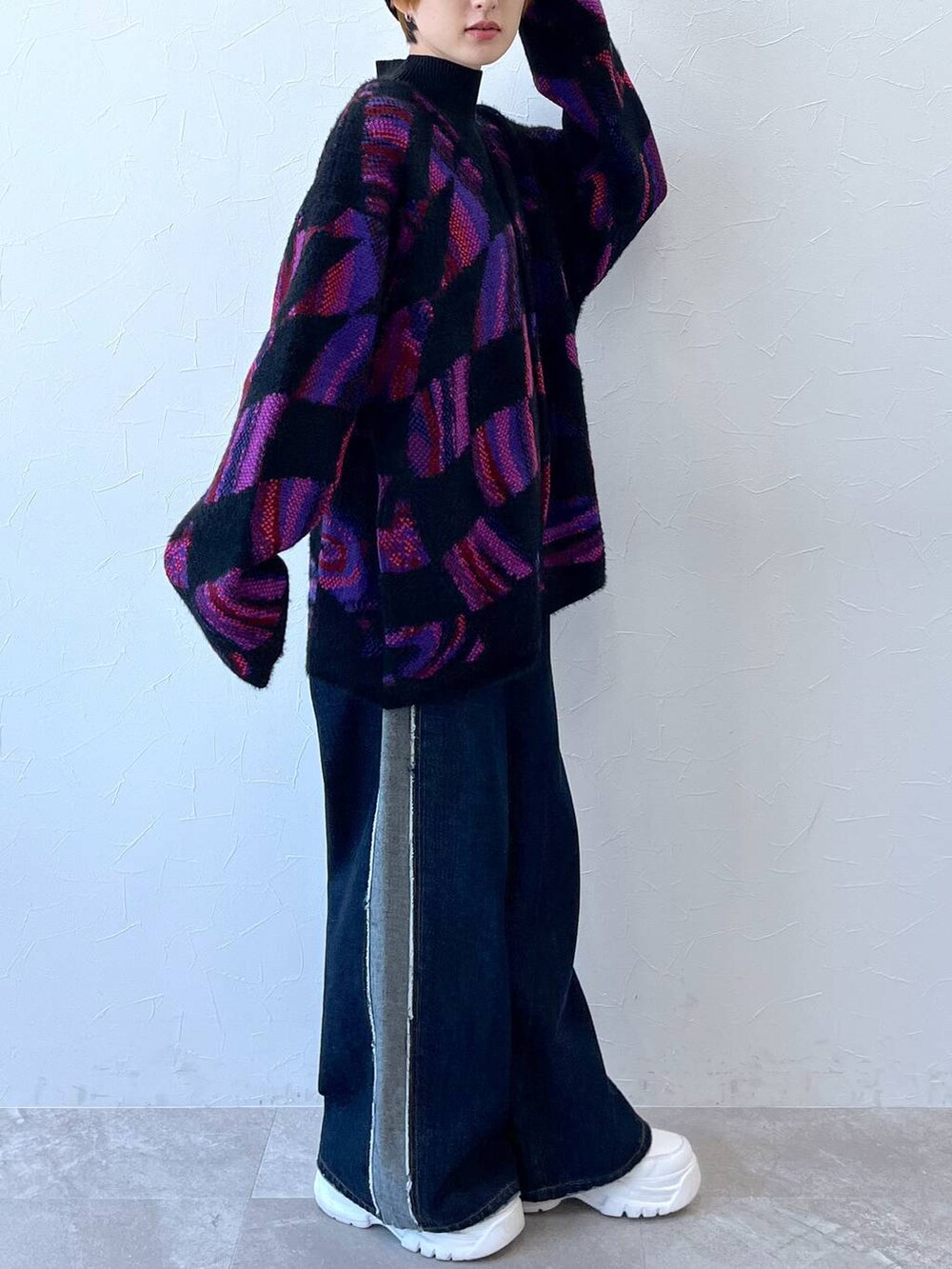 ブルー系のデニムパンツ、ブラック系のニット/セーター、ブラック系のニットキャップ/ビーニーを着用したレディースの秋コーディネートの7枚目の写真