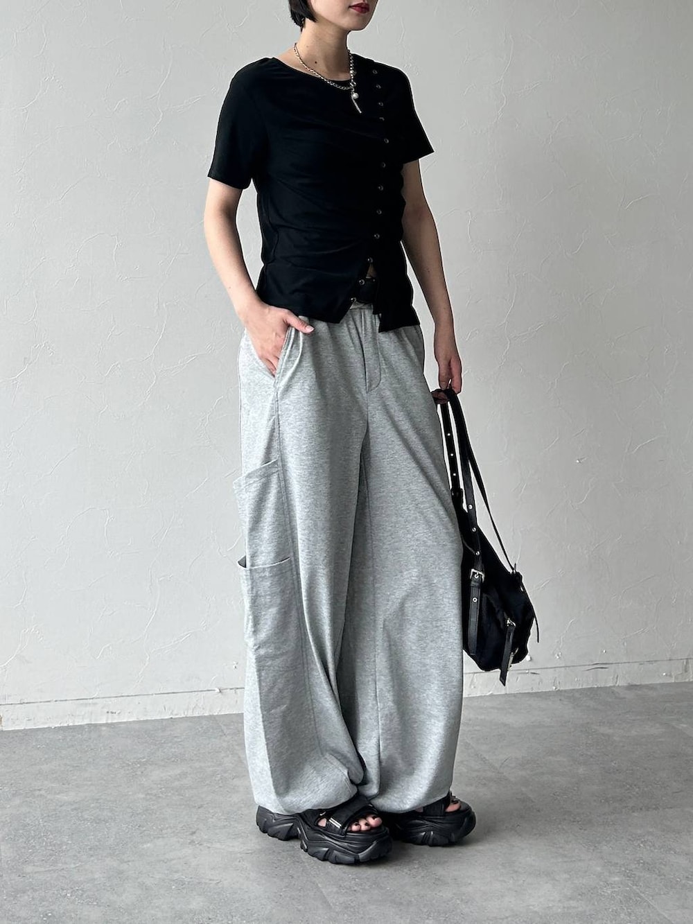 ブラック系のサンダル、ブラック系のトートバッグ、ブラック系のTシャツ/カットソーを着用したレディースの春コーディネートの3枚目の写真