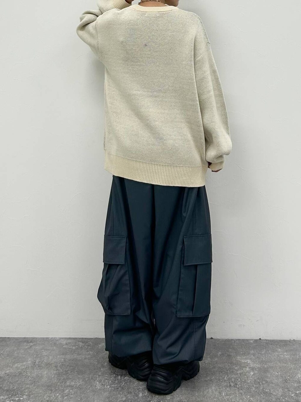 ブラック系のスニーカー、ホワイト系のニット/セーター、グレー系のカーゴパンツを着用したレディースの冬コーディネートの7枚目の写真