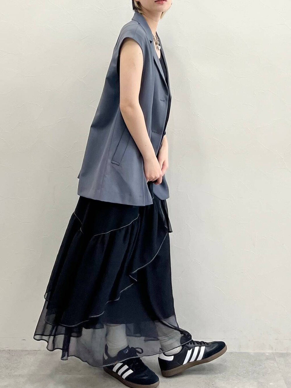 ブラック系のスカート、ブラック系のスニーカー、ブラック系のキャミソールを着用したレディースの春コーディネートの5枚目の写真