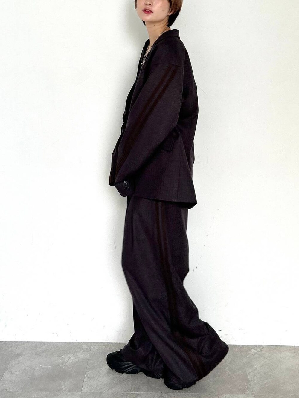 ブラウン系のスラックス、ブラウン系のテーラードジャケット、ブラック系のベルトを着用したレディースの秋コーディネートの4枚目の写真