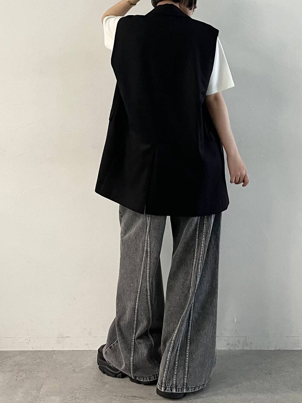 ブラック系のスニーカー、ブラック系のデニムパンツ、ブラック系のその他アウターを着用したレディースの春コーディネートの6枚目の写真