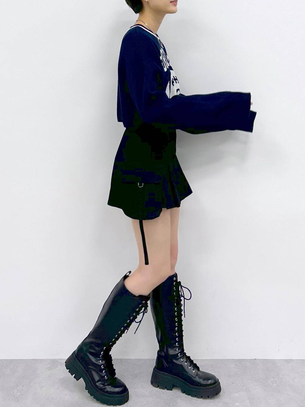 ブラック系のブーツ、ブラック系のスカート、ブルー系のニット/セーターを着用したレディースの冬コーディネートの5枚目の写真