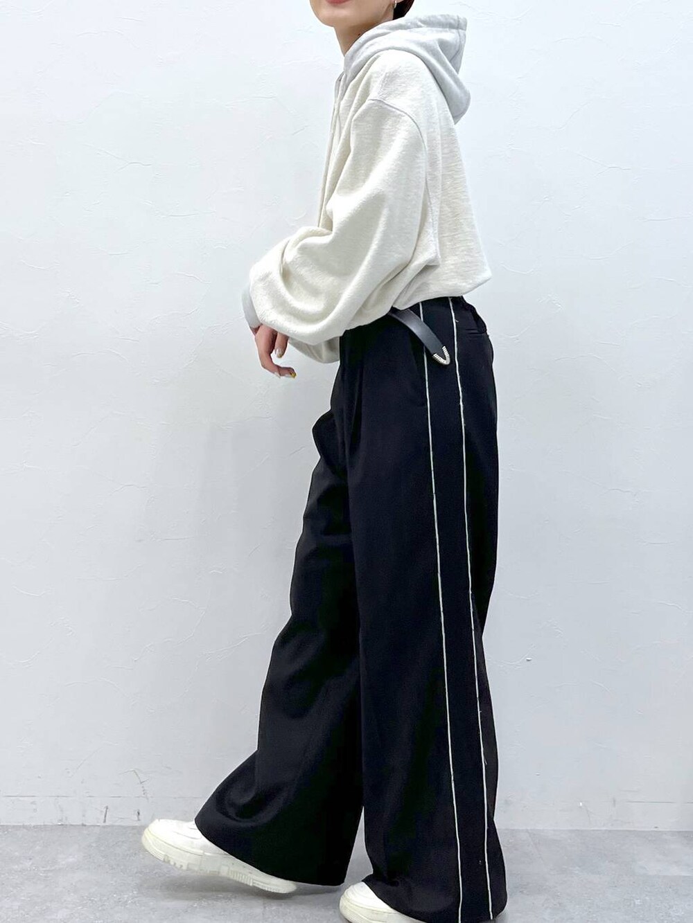 ブラック系のスラックス、グレー系のパーカーを着用したレディースの秋コーディネートの4枚目の写真