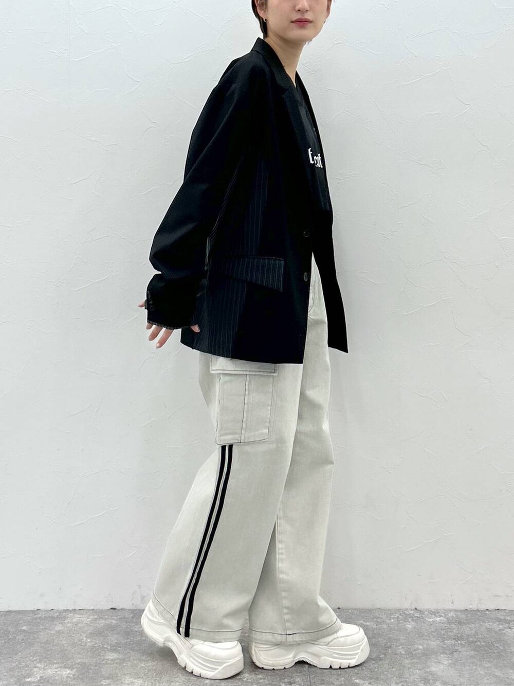 ブラック系のテーラードジャケット、ホワイト系のデニムパンツ、ブラック系のTシャツ/カットソーを着用したレディースの春コーディネートの4枚目の写真