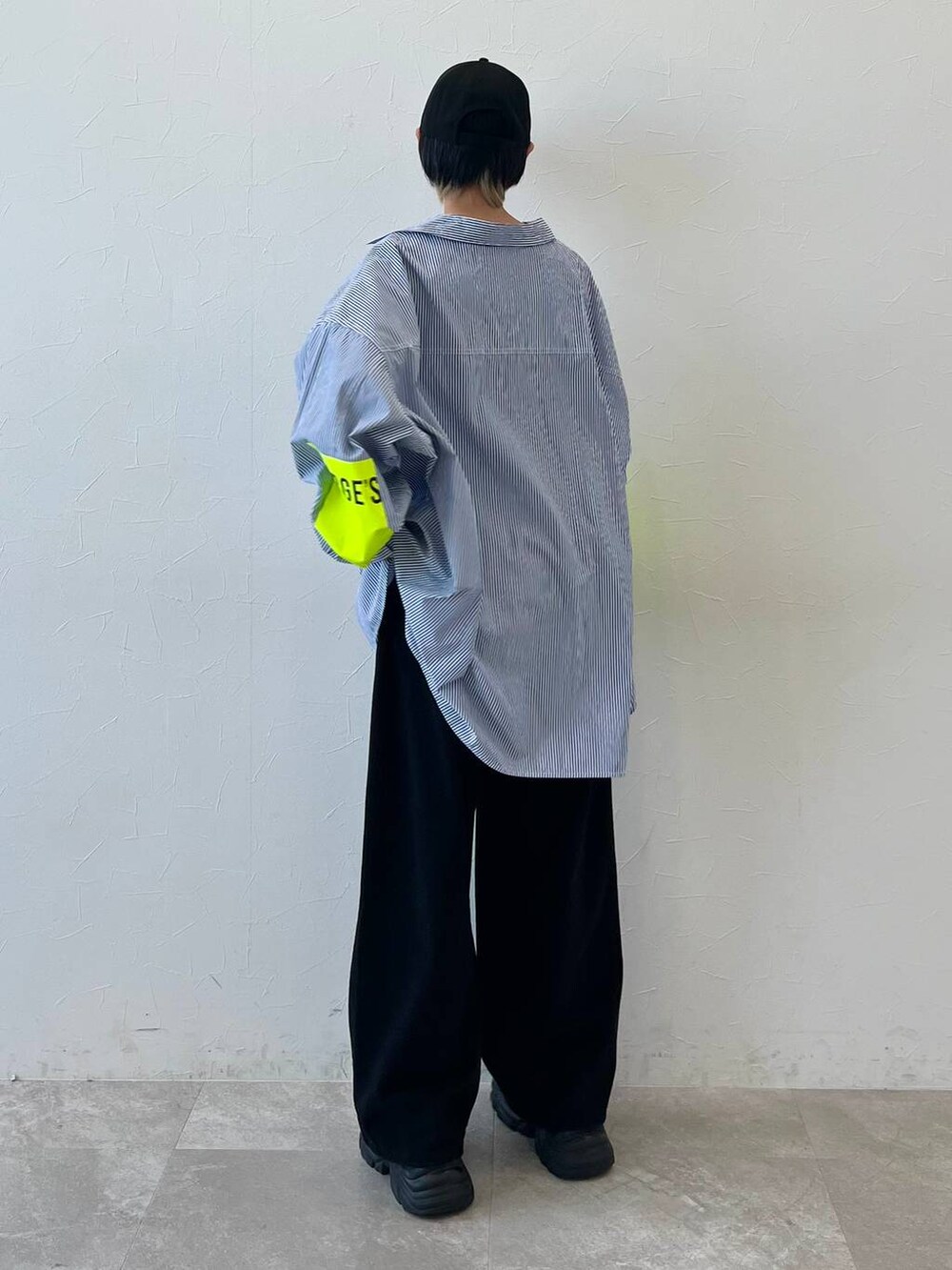 ブラック系のスニーカー、ブラック系のチノパンツ、ブラック系のキャップを着用したレディースの春コーディネートの5枚目の写真