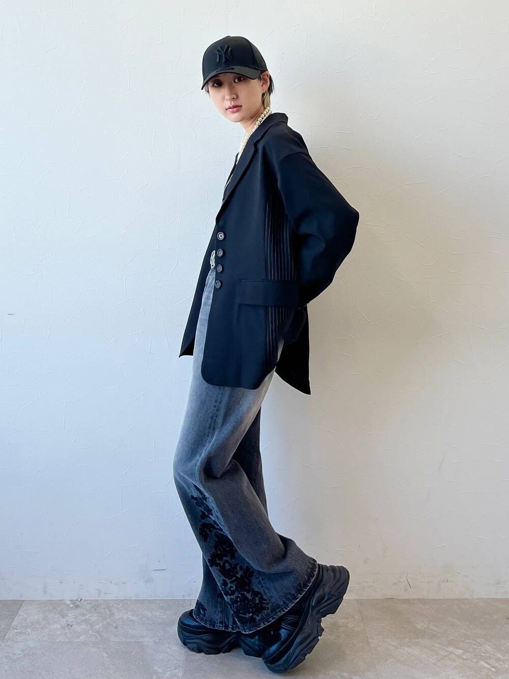 ブラック系のスニーカー、ブラック系のキャミソール、ブラック系のテーラードジャケットを着用したレディースの春コーディネートの3枚目の写真