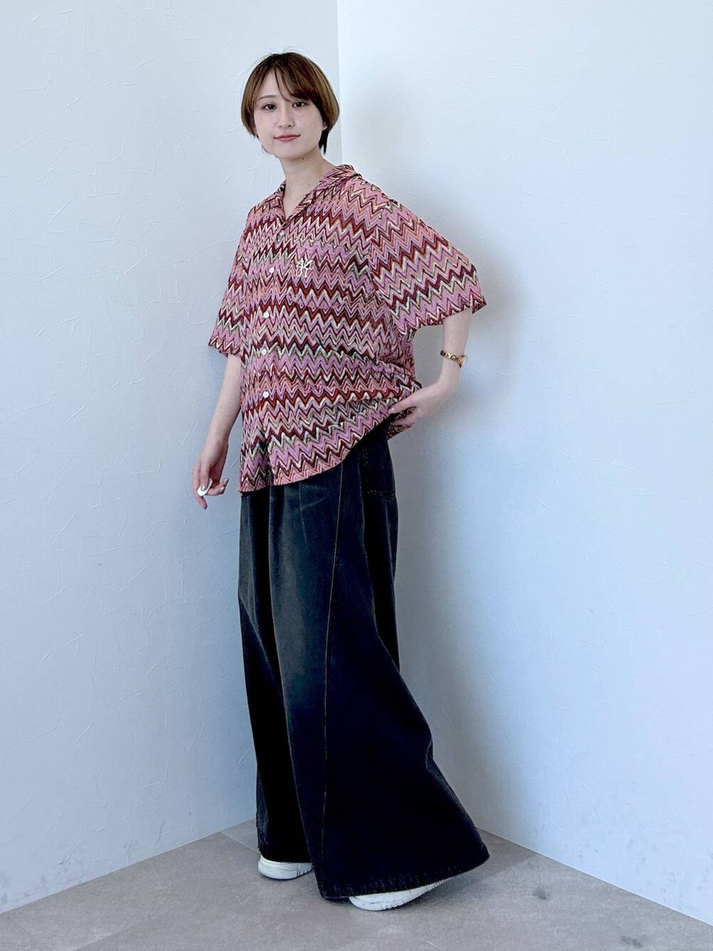 ピンク系のシャツ/ブラウス、ブルー系のデニムパンツを着用したレディースの春コーディネートの3枚目の写真