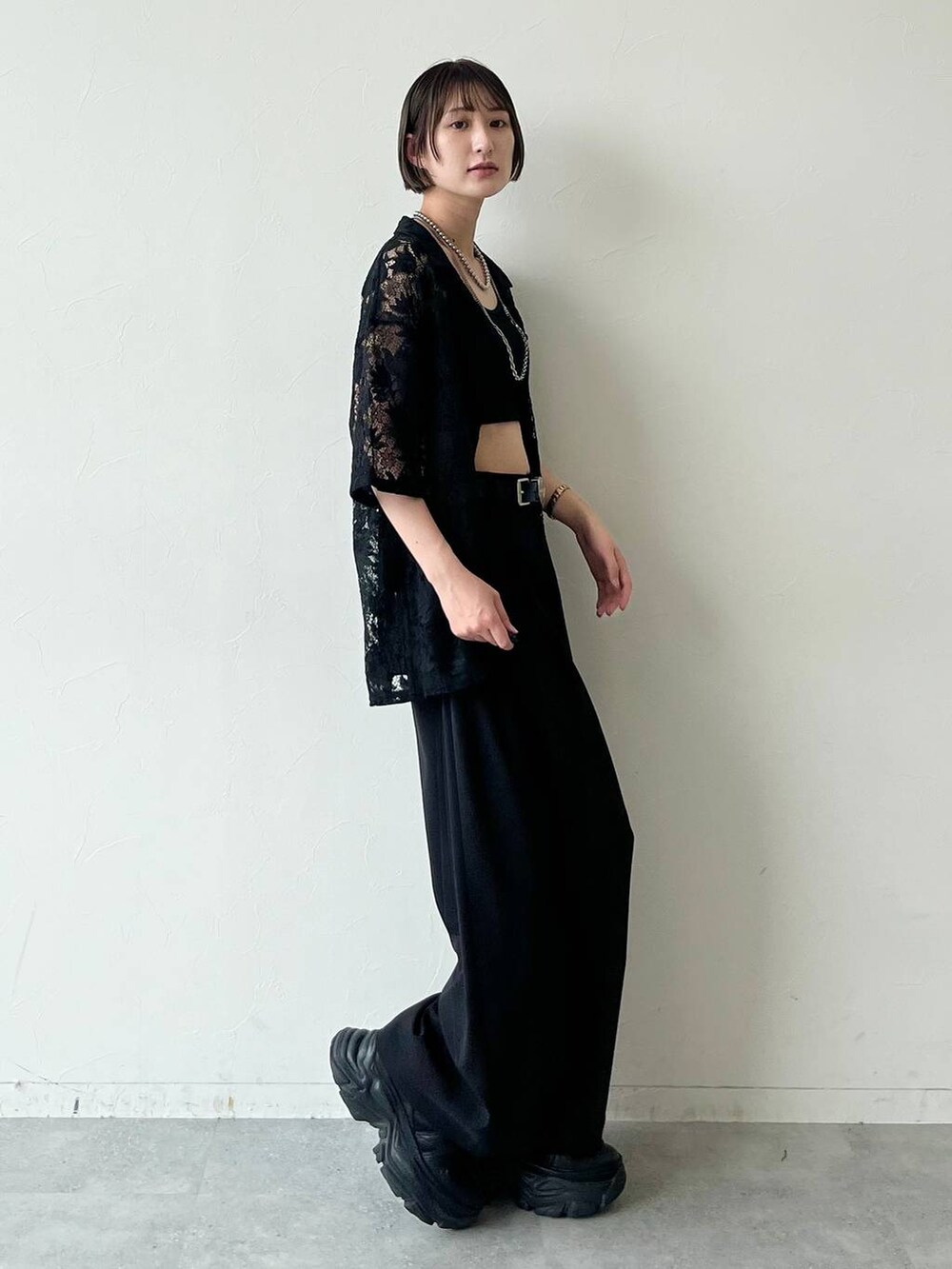 ブラック系のスニーカー、ブラック系のキャミソール、ブラック系のスラックスを着用したレディースの夏コーディネートの4枚目の写真